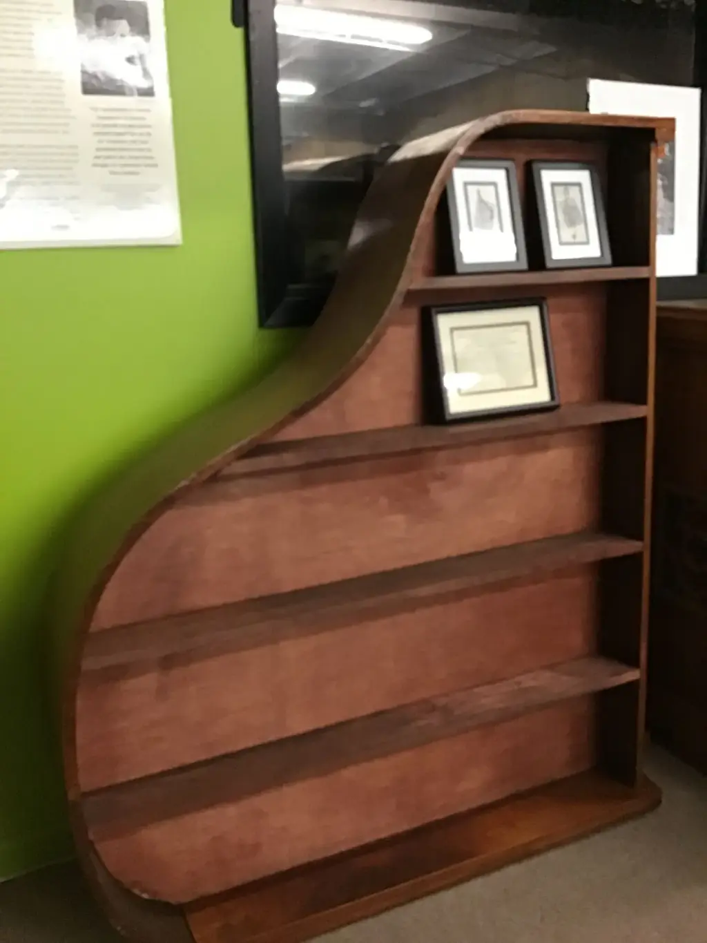Grand piano case rebuilt as a curved bookshelf